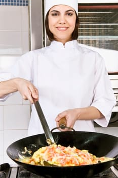 Female chef cooking food in the kitchen