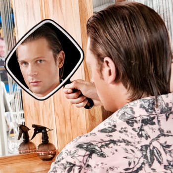 Man looking himself in a mirror after a haircut