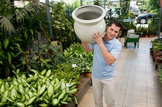 Customer holding a decorative urn in a greenhouse