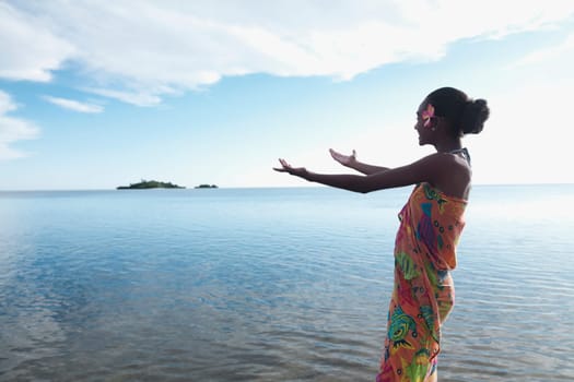Woman stretching her arms towards the sea