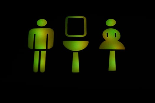 Close_up of illuminated male and female toilet signs in an airplane