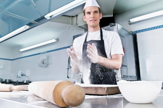 Chef dusting hands with flour