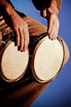 Close_up of a man playing a bongo