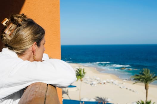 Woman looking at the sea view through a hotelŽs balcony, Cabo San Lucas, Mexico