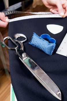Female tailor taking measurement in a clothing store