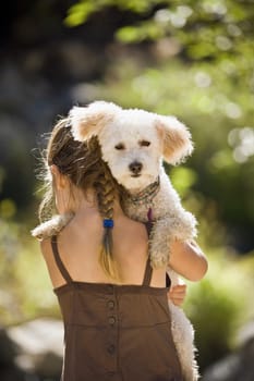 Rear view of a girl carrying her dog
