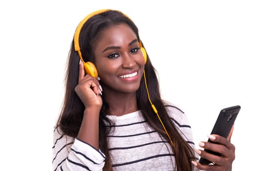 Beautiful young african woman listening to music, isolated over white