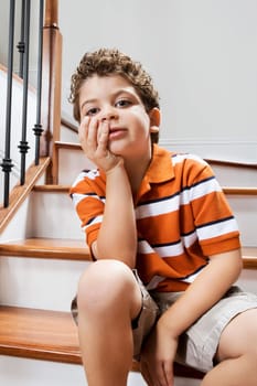 Boy sitting on a staircase and thinking