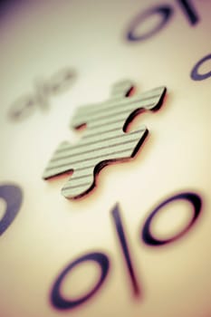 Close_up of a jigsaw piece with percentage signs