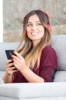Beautiful young woman relaxing on couch while listening to some music