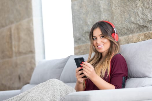 Beautiful young woman relaxing on couch while listening to some music