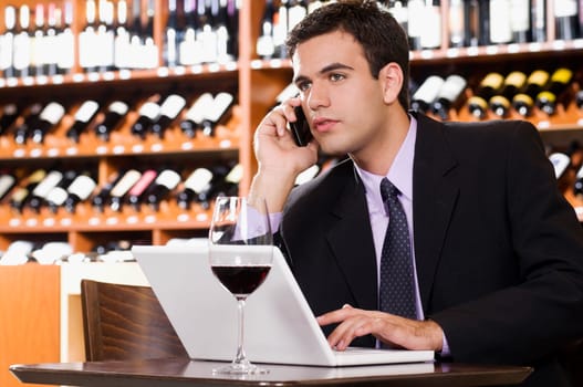 Businessman talking on a mobile phone in a bar