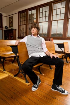 Teenage boy sitting in a classroom and thinking