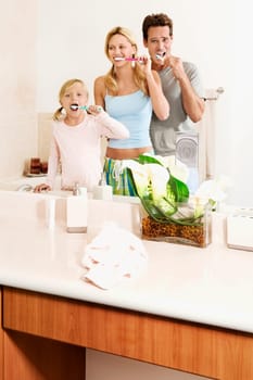 Family brushing teeth in the bathroom