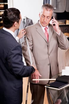 Tailor taking measurement of a businessman