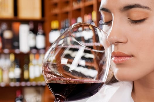 Businesswoman smelling a glass of red wine