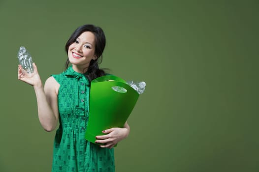 Portrait of a woman holding a recycling bin