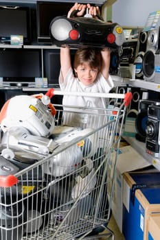 Boy carrying a stereo in a supermarket