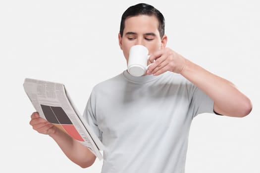 Close_up of a man reading a newspaper and drinking coffee