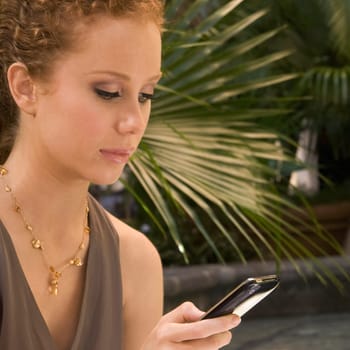 Woman text messaging on a mobile phone, Biltmore Hotel, Coral Gables, Florida, USA