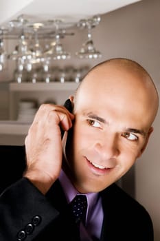 Businessman talking on a mobile phone in a bar