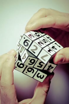 Close_up of a human hand holding a puzzle cube