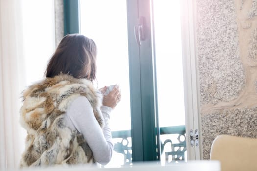 Woman relaxing at balcony enjoying sunrise. Good morning