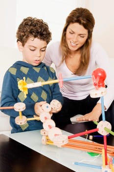 Woman assisting her son in assembling a toy