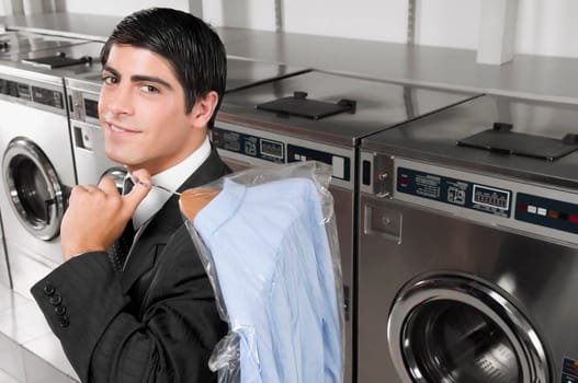 Businessman carrying a hanger in a laundromat