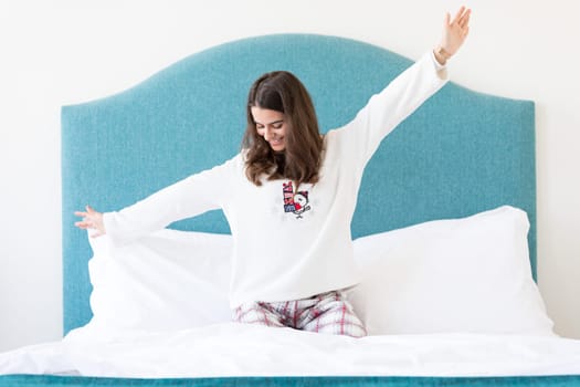 Beautiful happy young woman relaxing in bed