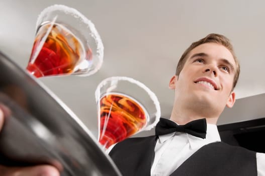 Waiter holding a tray of martini