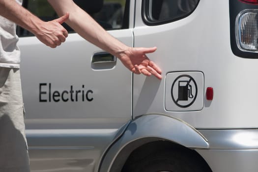 Man pointing at an electric car, Los Angeles, California, USA