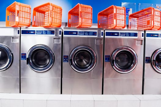 Laundry baskets on washing machines in a laundromat