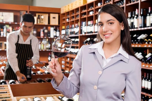 Businesswoman holding a glass of wine in a bar and smiling