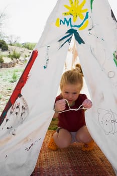 Girl tying knot of a tent, Santa Fe, New Mexico, USA