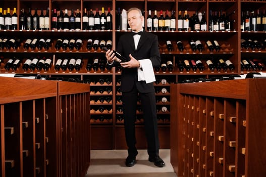 Businessman holding a wine bottle in a bar