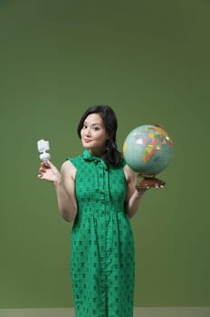 Portrait of a woman holding a globe and a light bulb
