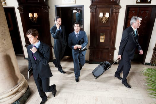 Four businessmen walking in a hotel lobby, Biltmore Hotel, Coral Gables, Florida, USA