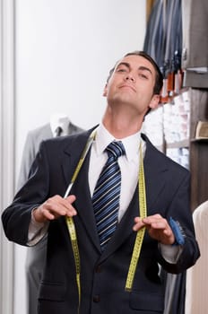 Portrait of a tailor holding a tape measure