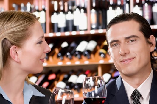 Business couple holding wine glasses and smiling