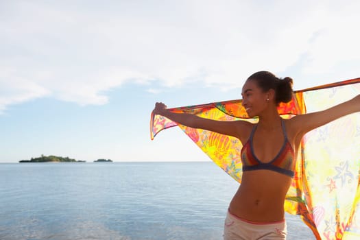 Woman holding a sarong on the beach