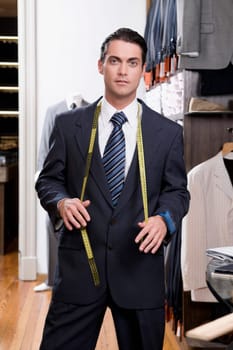 Portrait of a tailor holding a tape measure