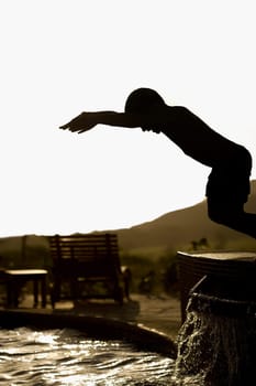 Boy preparing to jump into a swimming pool