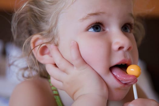 Baby girl licking a lollipop