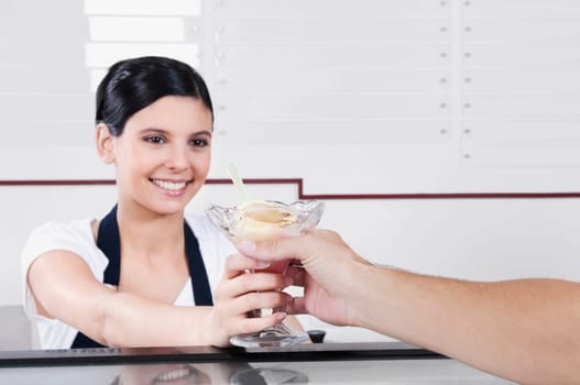 Female ice cream seller giving ice cream to a customer