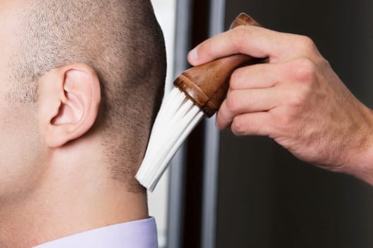 Barber using a brush on a manŽs neck