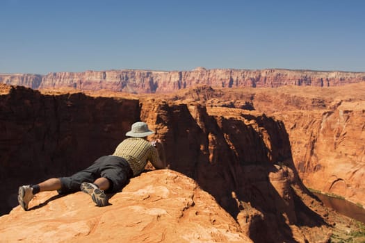 Man taking a picture of cliffs, Horseshoe Bend, Page, Arizona, USA