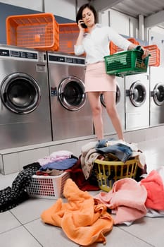 Woman talking on a mobile phone in a laundromat