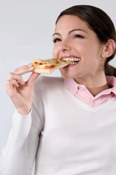 Female chef eating a slice of pizza