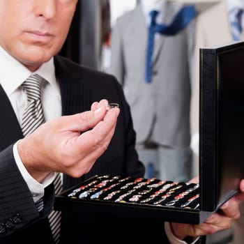 Businessman selecting cuff links in a clothing store
